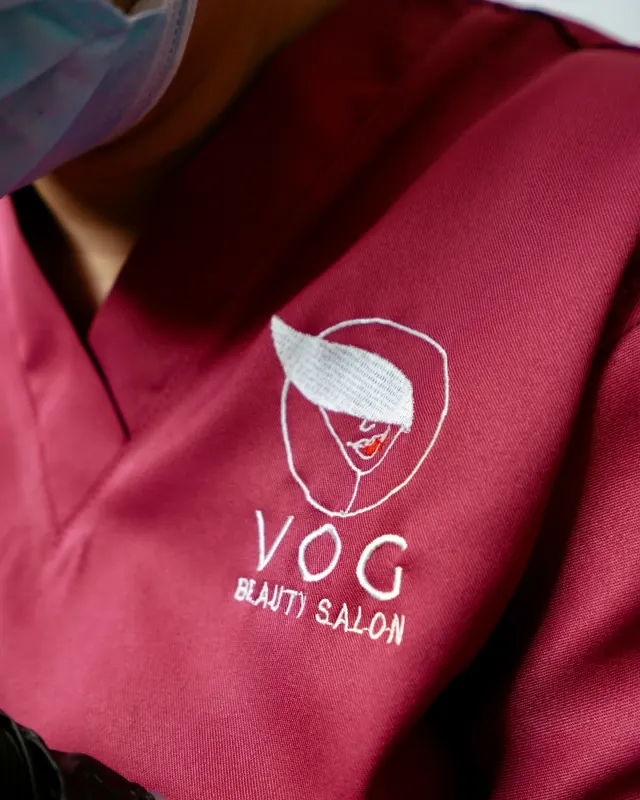 Embroidered VOG Beauty Salon logo on a staff uniform, brand detail photography