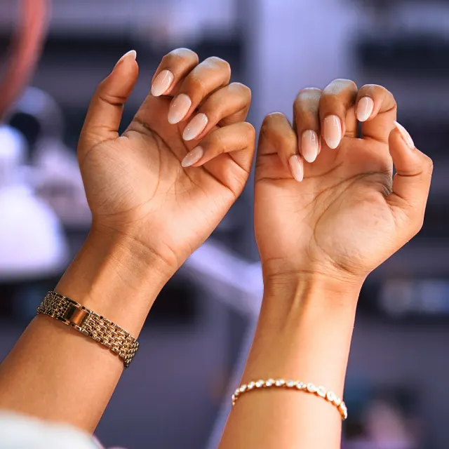 Hands showing a natural gel manicure with gold jewellery, shot for VOG Beauty Salon