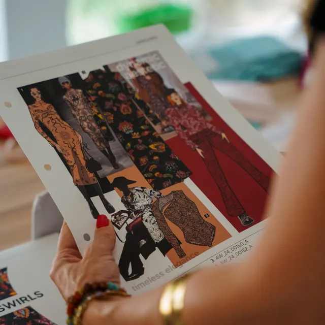 Fashion sketches held up for review, process photography for The Fashion Coterie