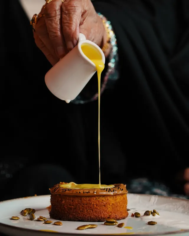 Sauce poured over a traditional aseeda dessert, food photography for Point Seven Coffee